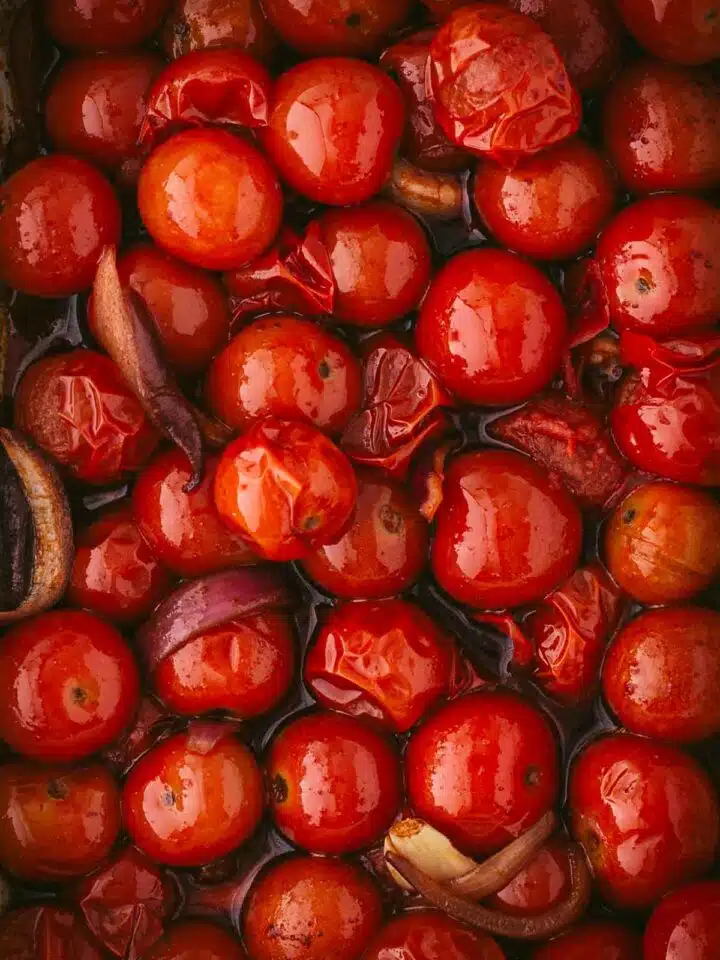Close up of roasted cherry tomatoes and garlic.