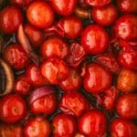 Roasted cherry tomatoes and garlic in a pan.