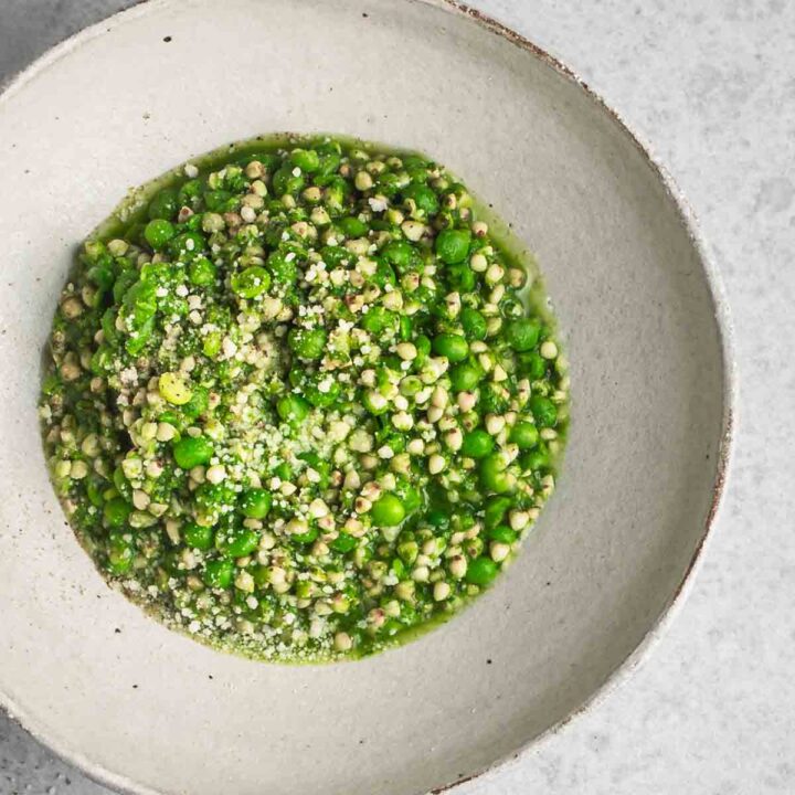Green pea risotto in a bowl close up.