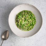 Green pea risotto in a bowl close up.