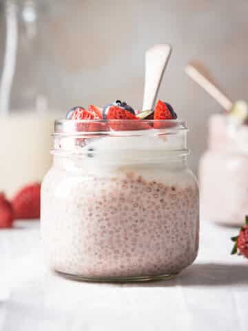 A jar of chia pudding with strawberries.