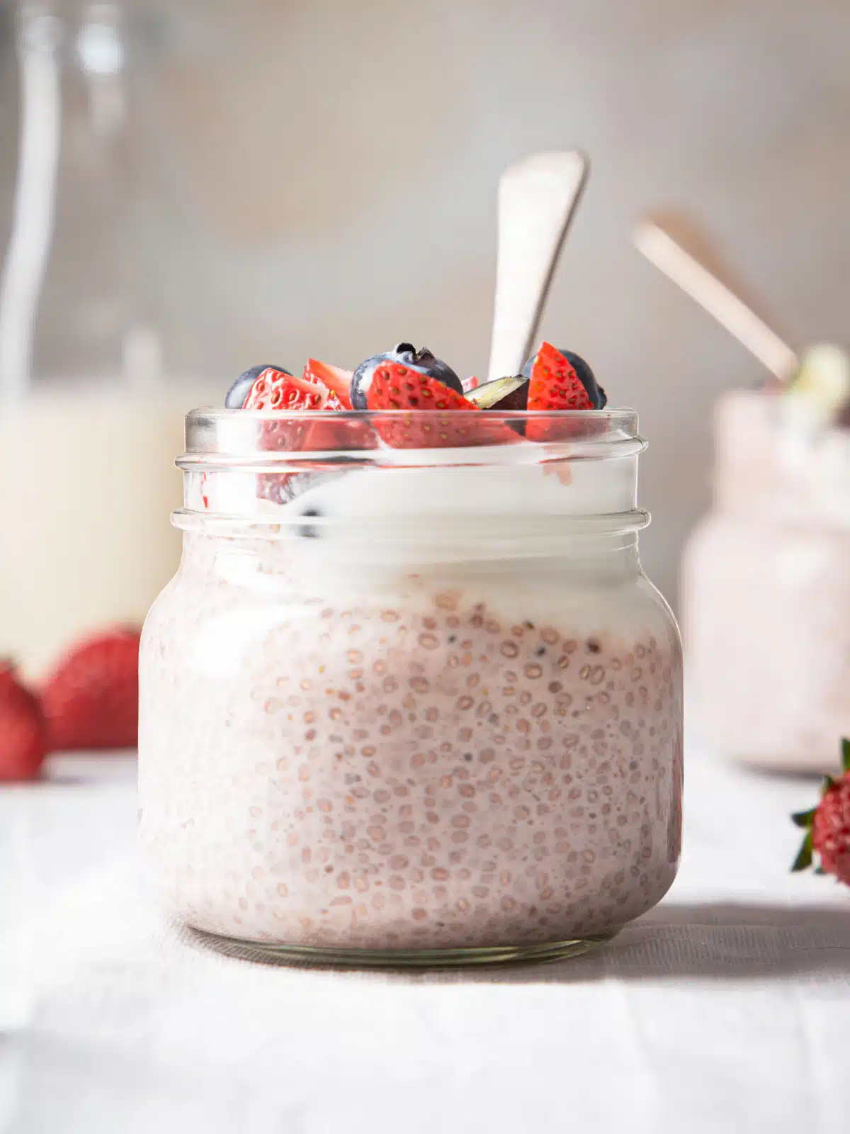 A jar of chia pudding with strawberries.