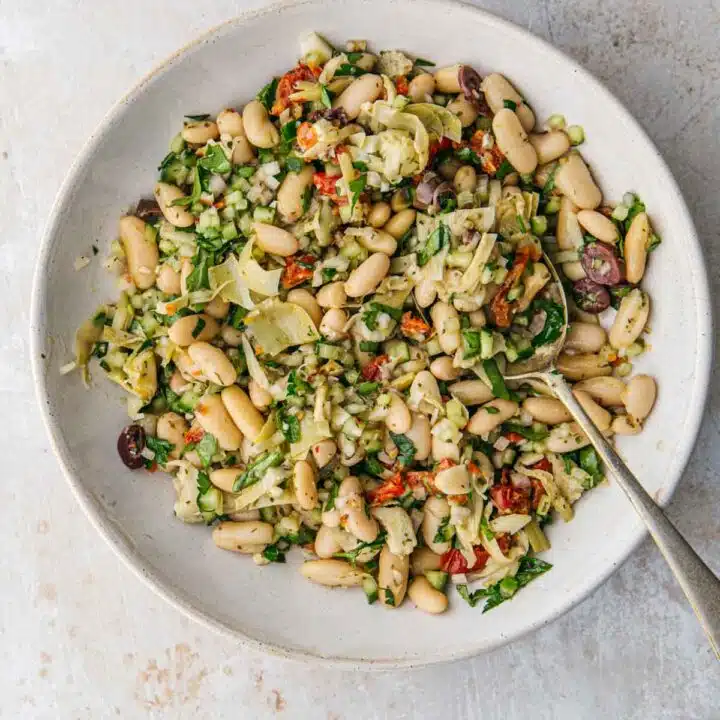 A bowl of salad with white beans.