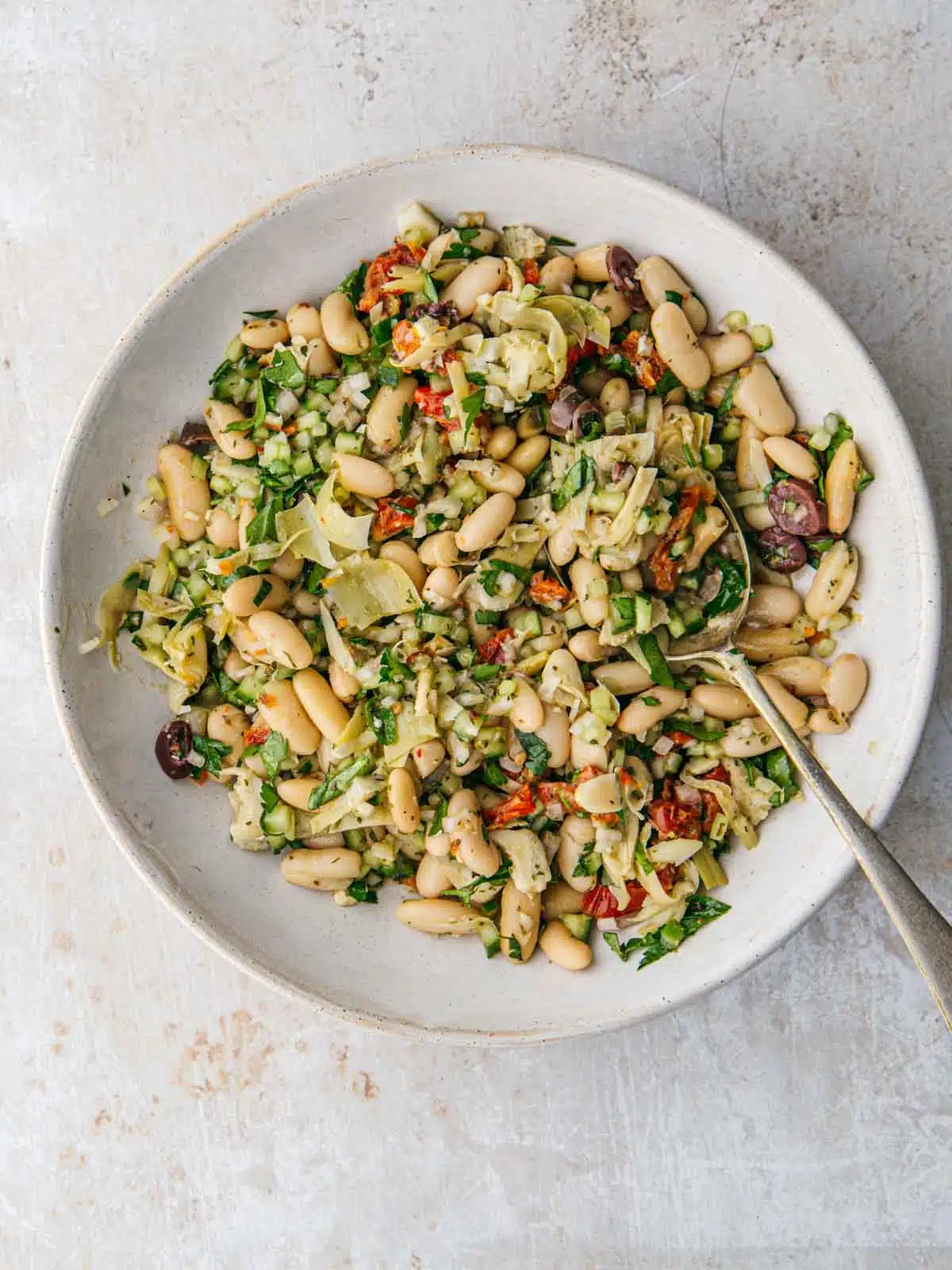 A bowl of salad with white beans.
