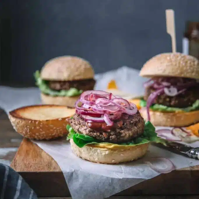 Burgers on a wooden board.