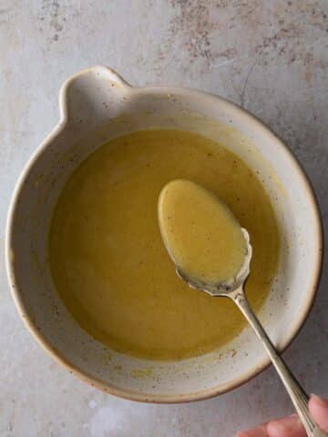 A bowl of maple Dressing with a spoon.