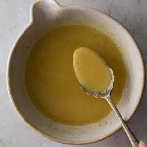 A close up image of maple dijon mustard with a spoon.