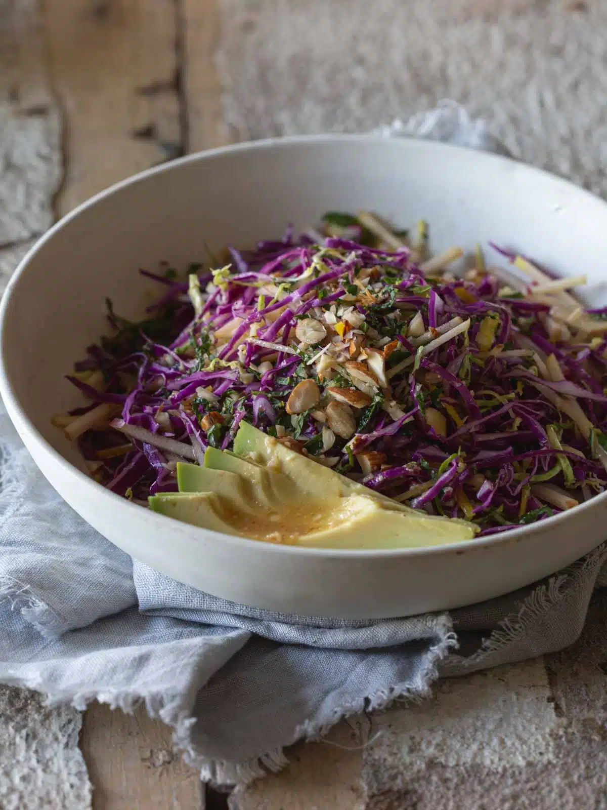 Rainbow salad and avocado in a bowl.