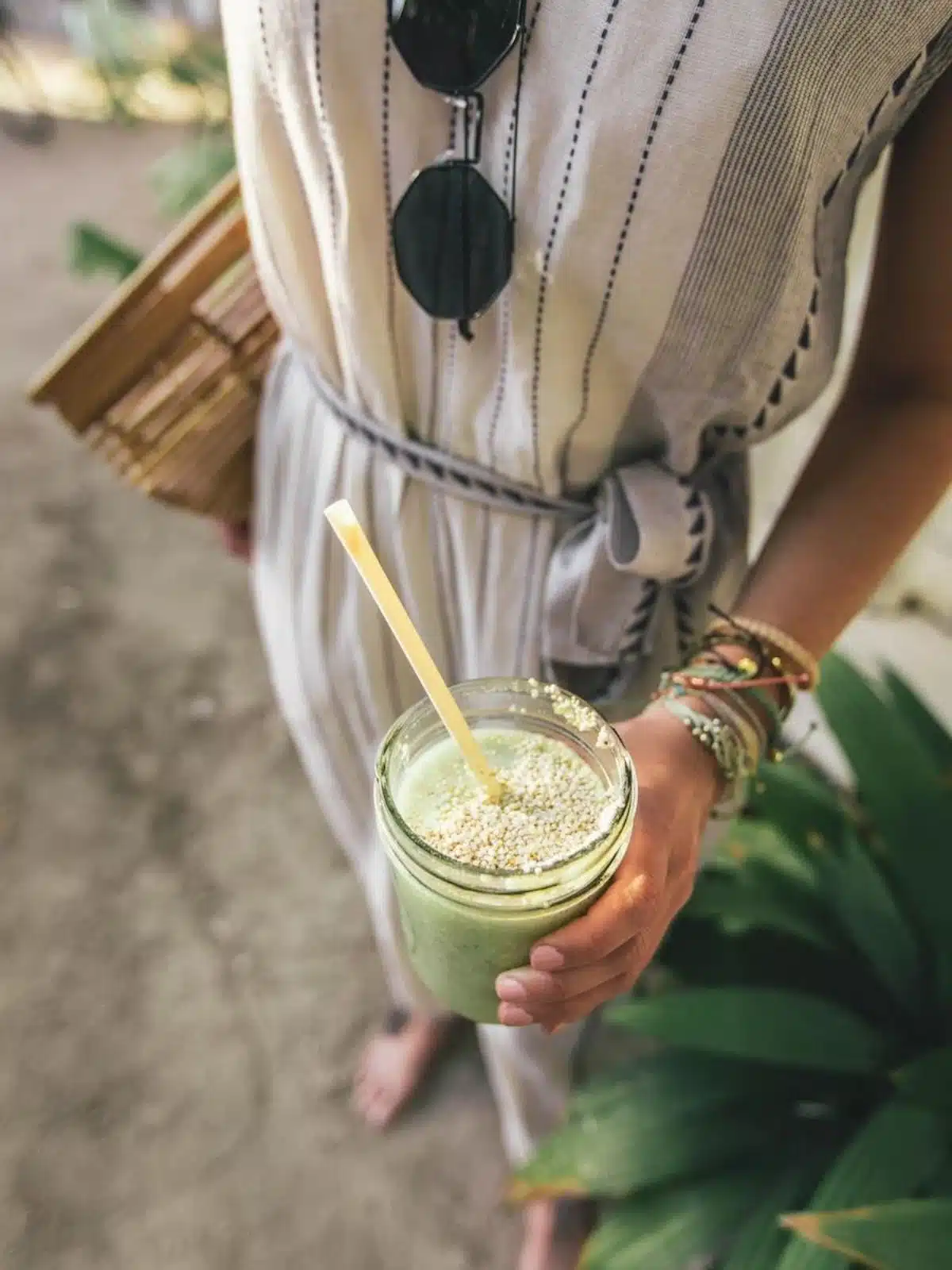 A woman holding a green drink with seeds.