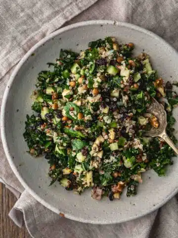 Kale and Quinoa salad with lentils, walnuts and currants in a bowl.