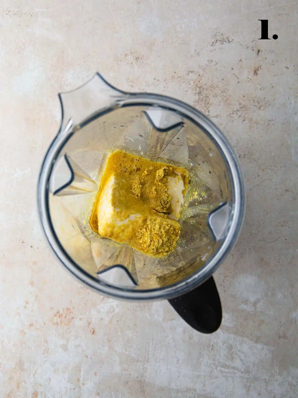 Tofu and nutritional yeast with soy milk in a blender.