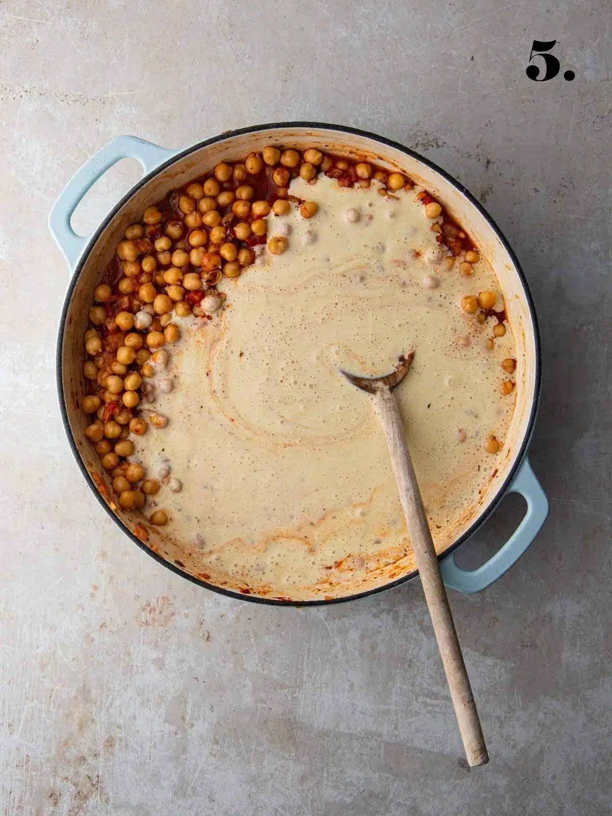 A creamy sauce added to tomatoes and chickpeas in a pan for Marry Me Chickpeas recipe.