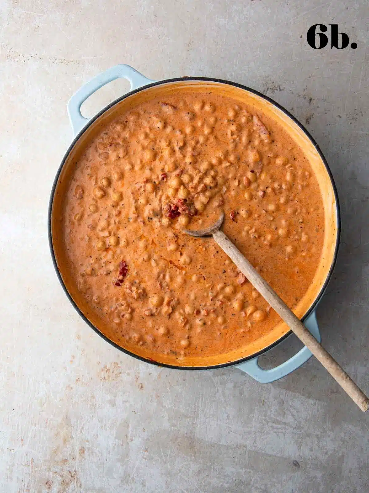 Marry me chickpeas with sun-dried tomatoes in a pan with a wooden spoon