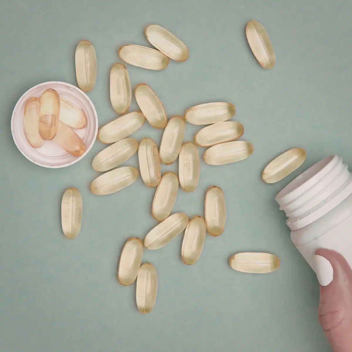 Supplement capsules on an aqua background.