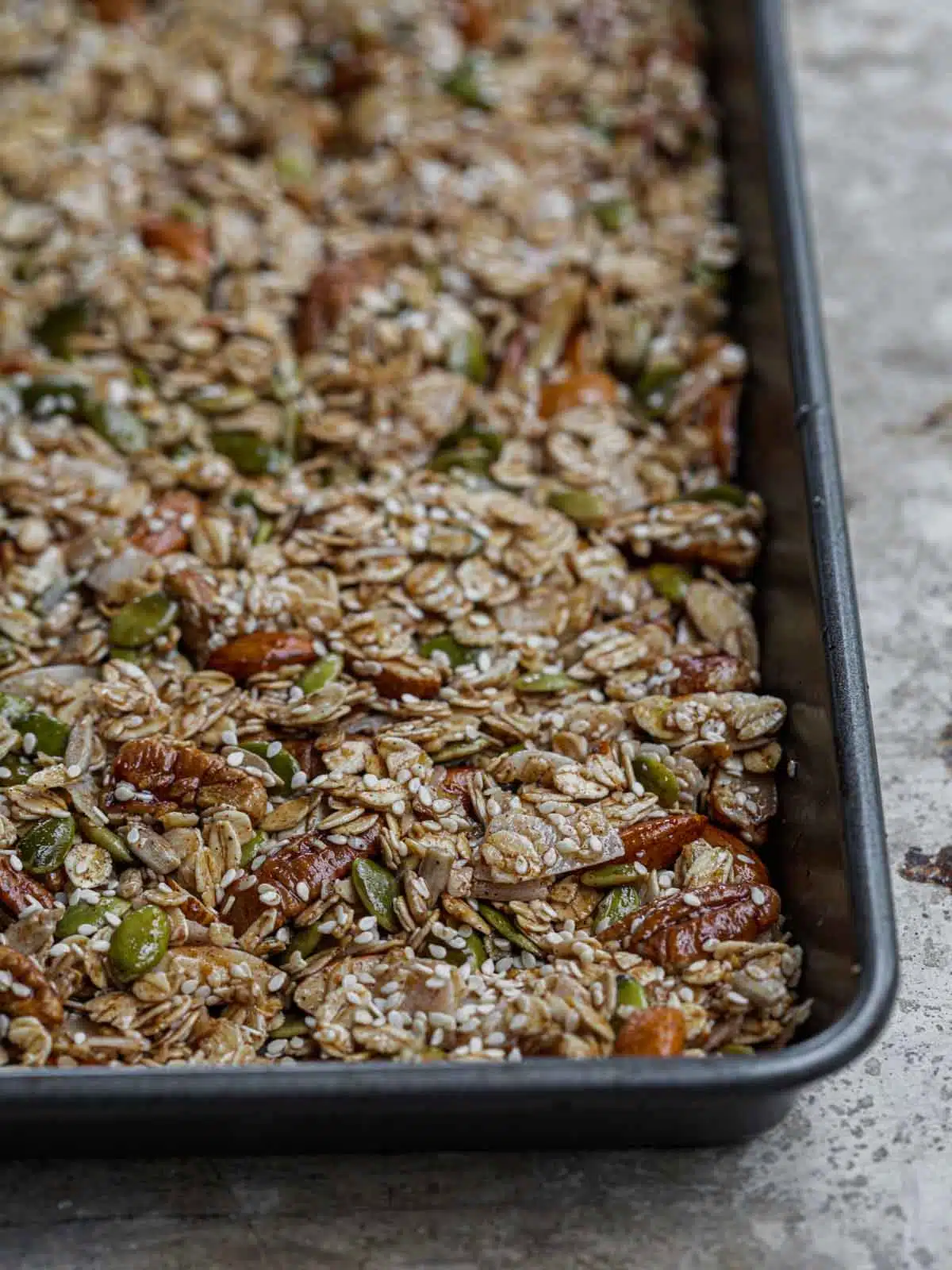 Sesame granola pressed into a baking pan before baking.
